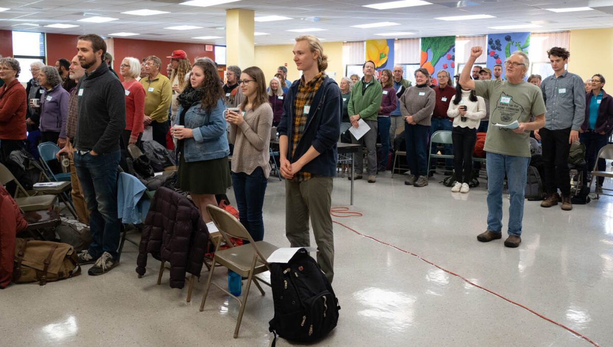 Group of people standing and facing in same direction.