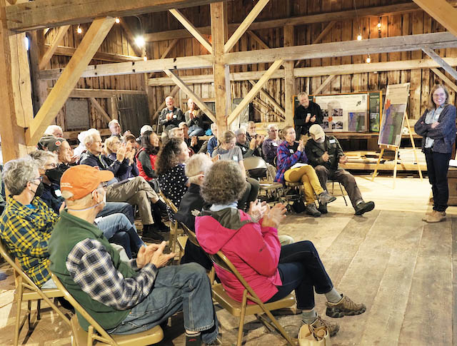 People listening to a presenter in a restored barn.
