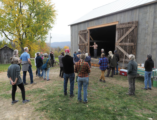 People listening to David Brynn speak from the door of his barn