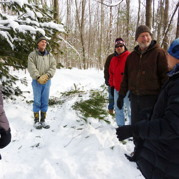People listening to someone speak in a winter woods