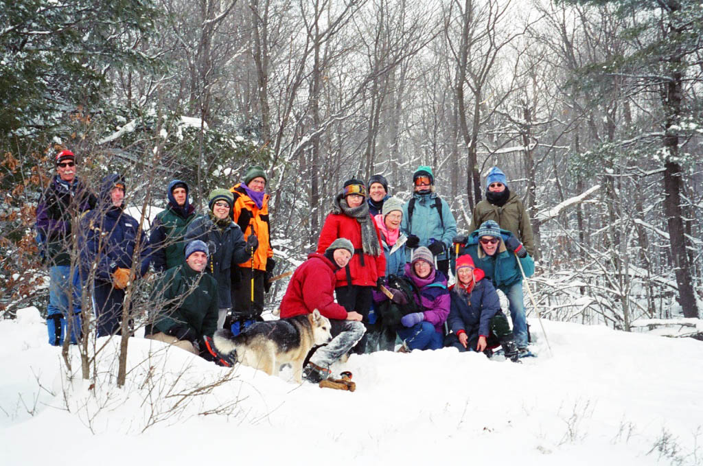 Group of people gathered for a photo in the winter woods