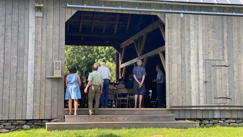 people standing in a barn.